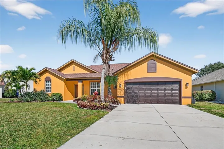 Ranch-style home featuring stucco siding, a front lawn, concrete driveway, and an attached garage