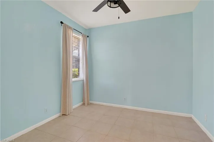 Guest suite bedroom with ceiling fan and light tile patterned floors