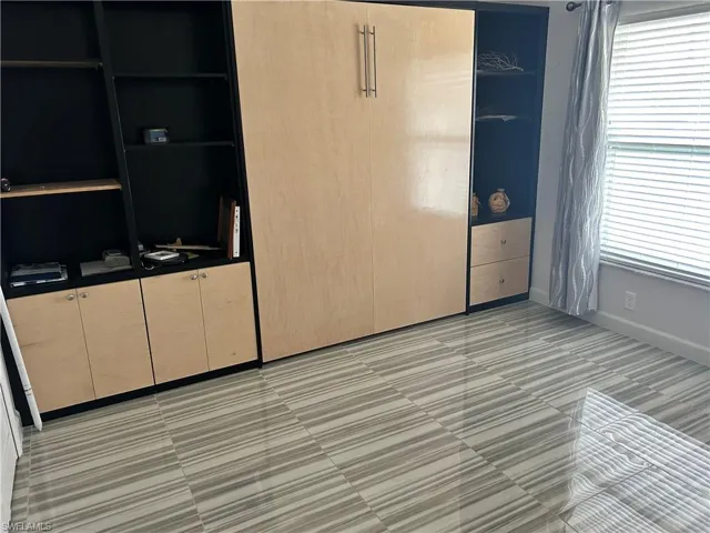 Unfurnished bedroom featuring multiple windows and light tile patterned floors