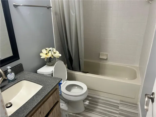 Full bathroom featuring vanity, tile patterned flooring, toilet, and shower / bath combo