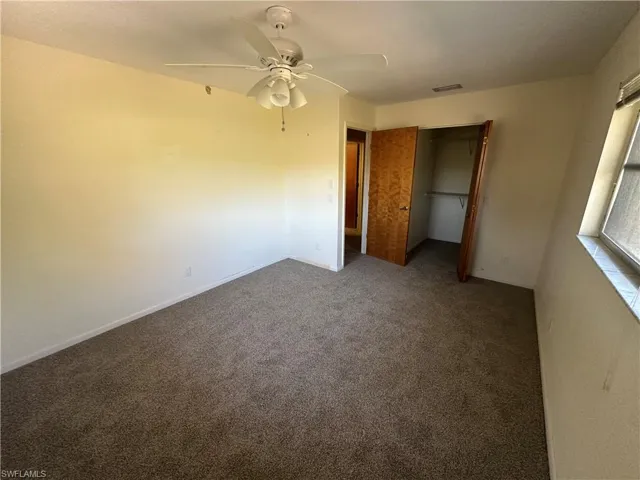 Unfurnished bedroom featuring carpet floors, a closet, and a ceiling fan
