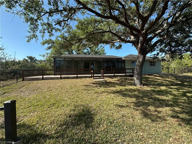 Back of property with a sunroom and a fenced backyard
