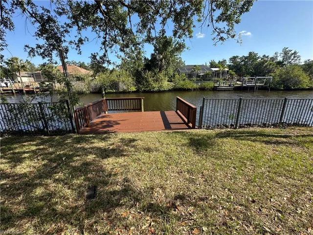 Dock area with a lawn and a water view.  One bridge to harbor and Gulf.