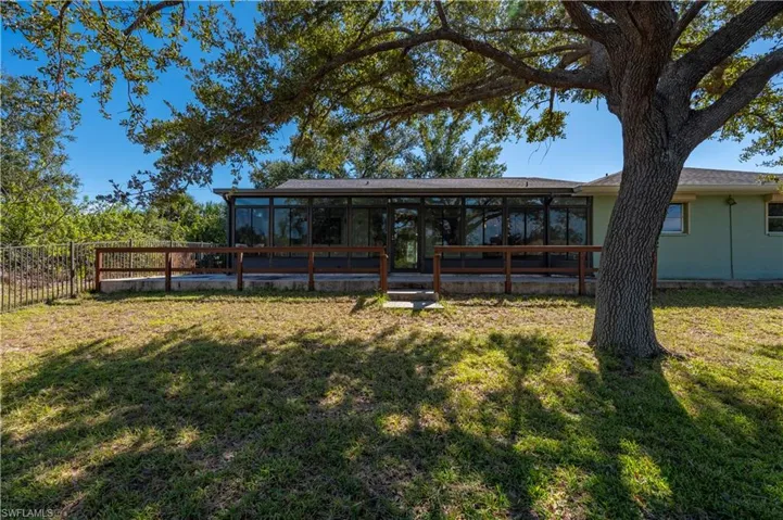 Back of property with a sunroom and a yard