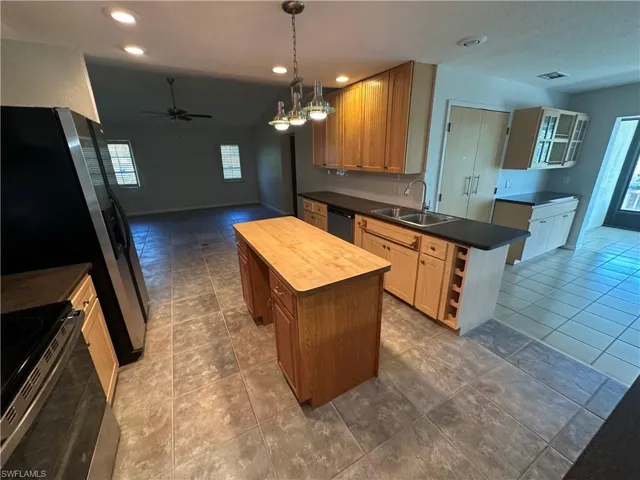 Kitchen with stainless steel appliances, healthy amount of natural light, a kitchen island, a ceiling fan, and recessed lighting