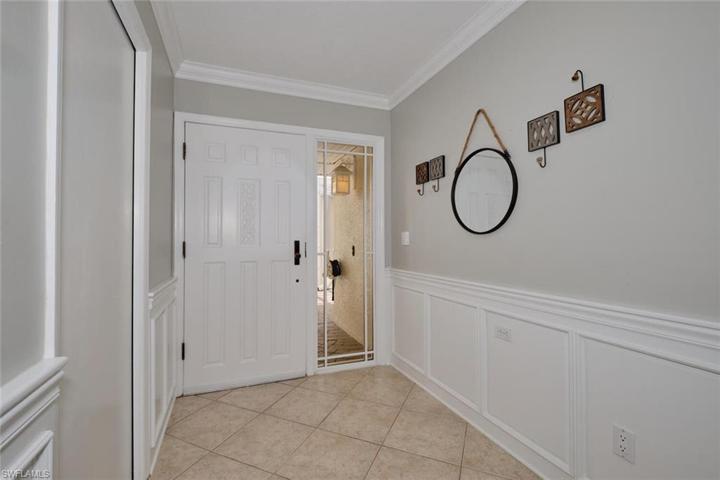 Front entry features tile floors, wainscoting and crown molding.