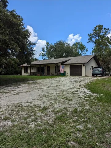 Ranch-style house featuring a porch and a garage