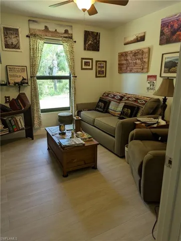 Living room with ceiling fan and light hardwood / wood-style floors