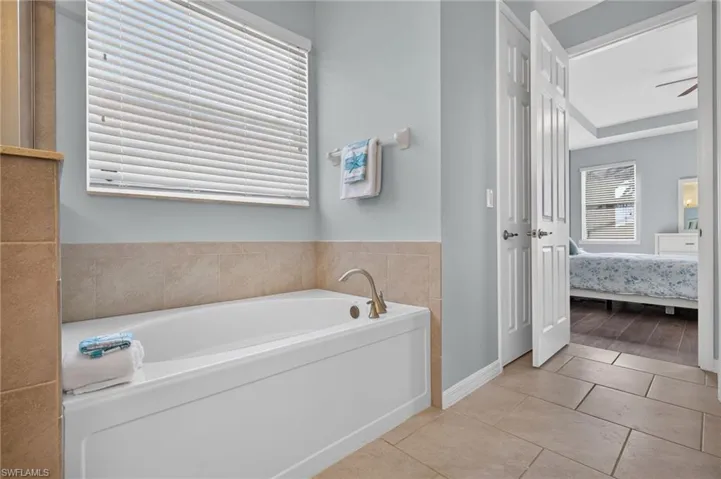 Soaking tub with brushed nickel fixtures and a tiled surround