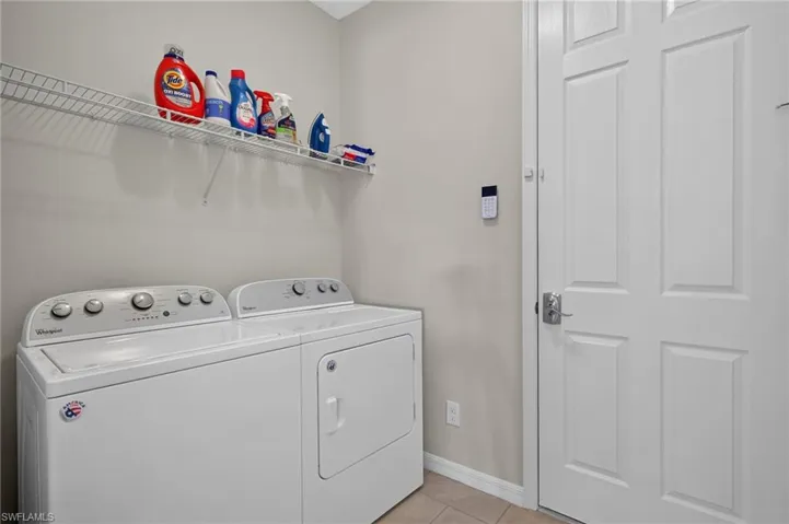 Dedicated laundry space featuring a white wire shelving unit