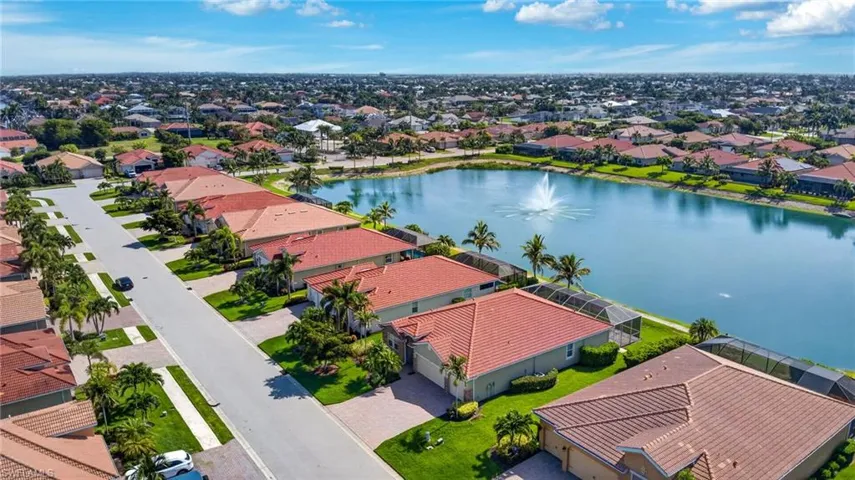 Aerial perspective showcasing a residential area with a prominent central lake featuring a fountain
