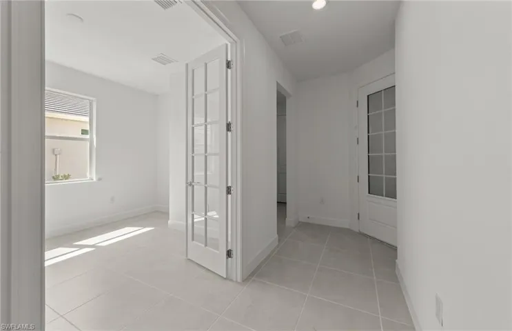 Hallway featuring light tile floors