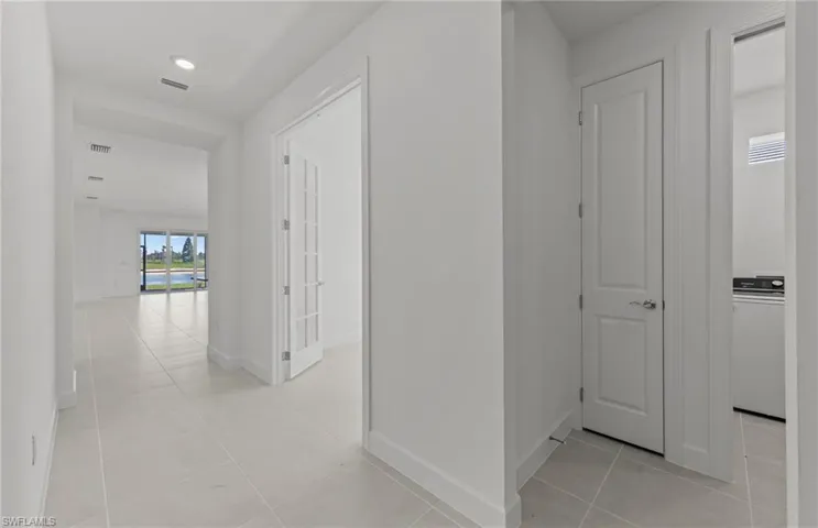 Hallway featuring washer / clothes dryer and light tile floors
