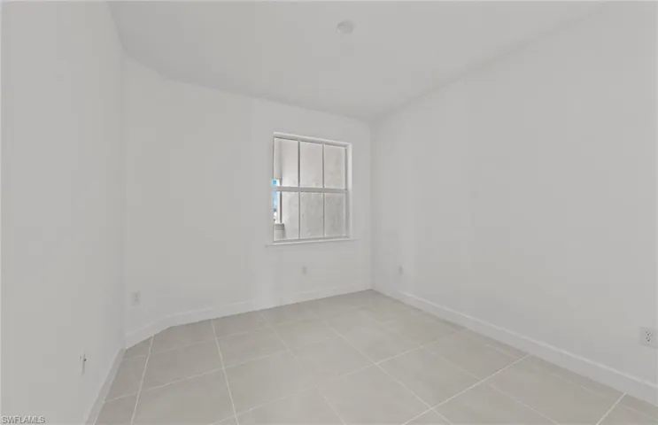 Empty room with light tile flooring