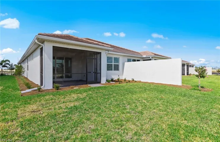 Rear view of property featuring a sunroom and a lawn