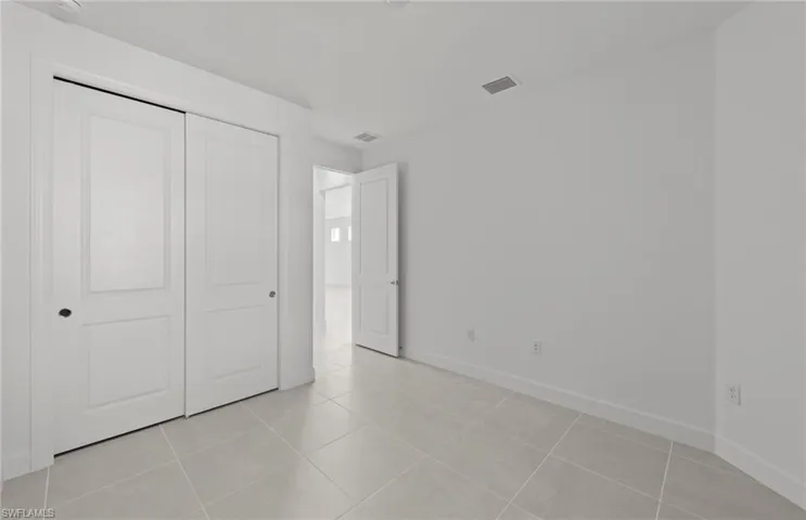 Unfurnished bedroom featuring a closet and light tile floors