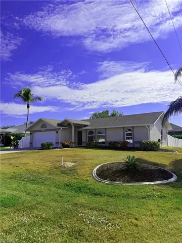 Ranch-style home with stucco siding, a garage, and driveway