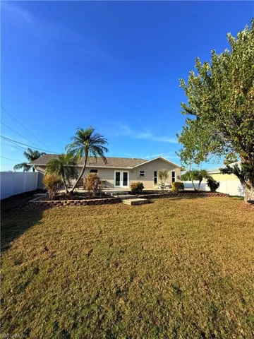 Back of house with a fenced backyard and french doors