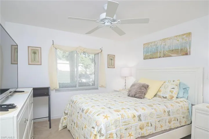 Bedroom with ceiling fan and light colored carpet