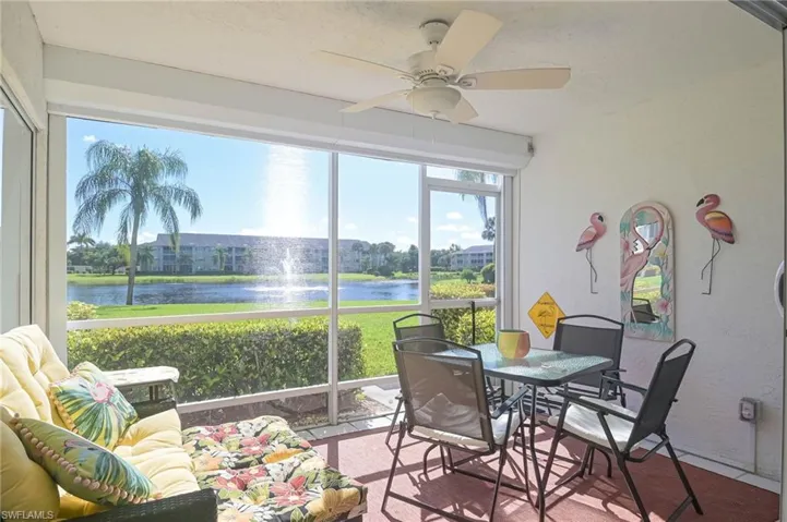 Sunroom / solarium with ceiling fan and a water view