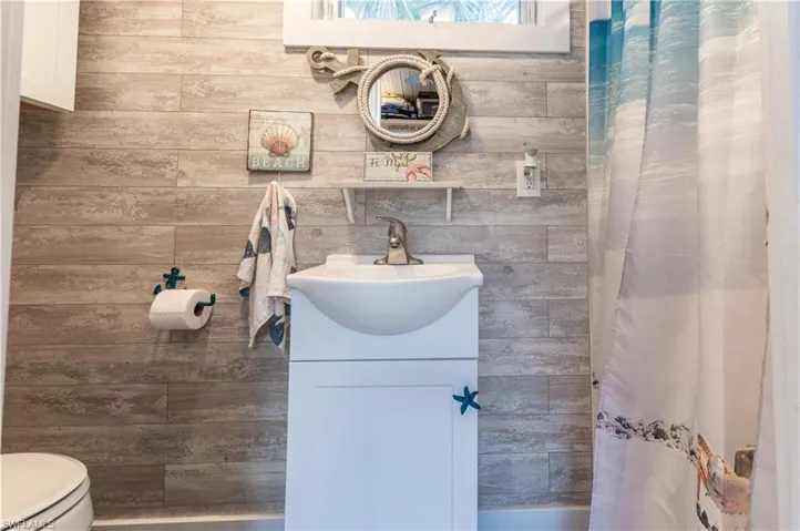 Full bath featuring curtained shower and vanity
