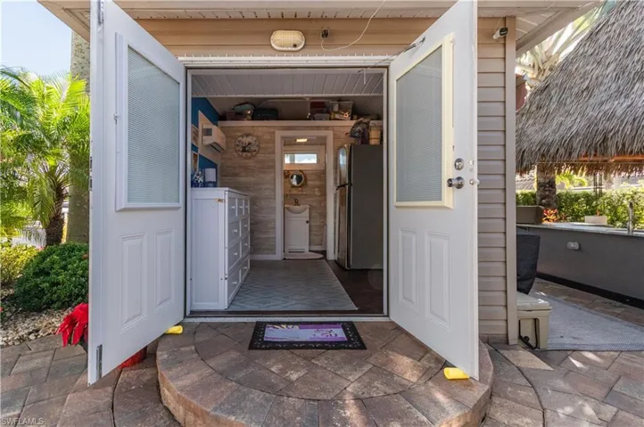 Doorway to property featuring a patio area and a wall mounted AC