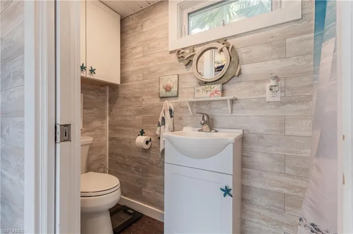 Half bathroom featuring vanity and wooden walls