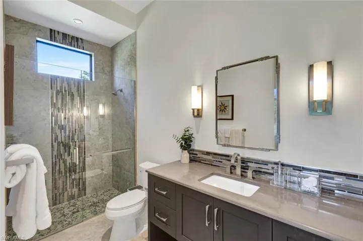 Guest bathroom #3 with beautiful tile detail and transom window allowing natural light to flow through