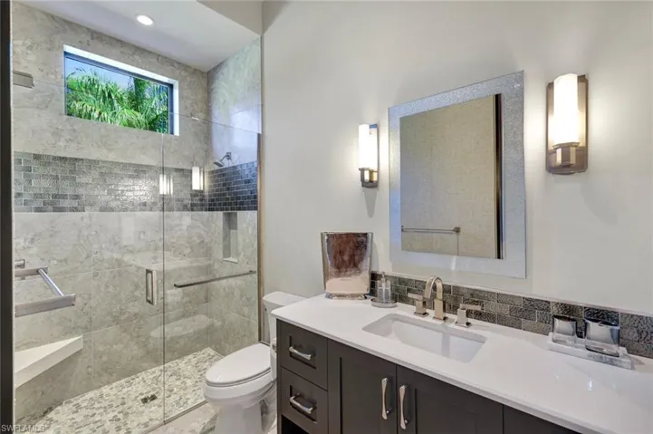 Guest bathroom #1 with beautiful tile work, a transom window, and lovely finishes