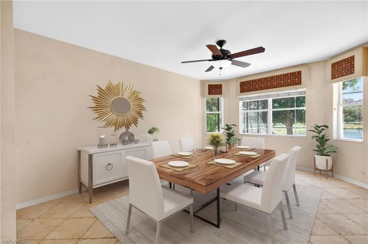 Dining room featuring a ceiling fan and light stone finish floors
