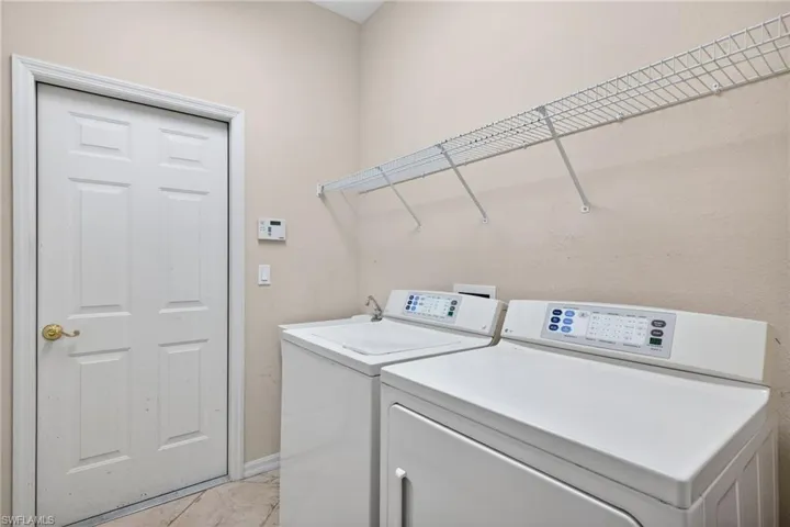 Laundry area with washing machine and dryer and baseboards