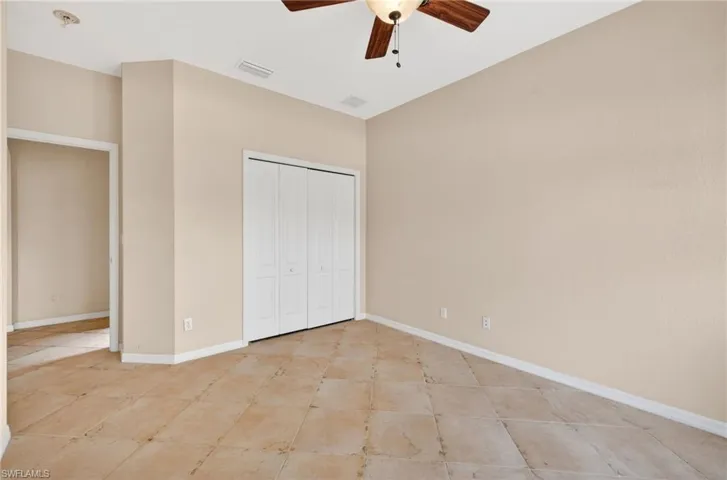 Unfurnished bedroom featuring a ceiling fan and a closet