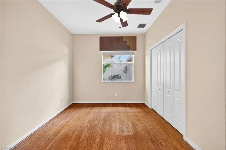 Unfurnished bedroom featuring light wood finished floors, ceiling fan, and a closet