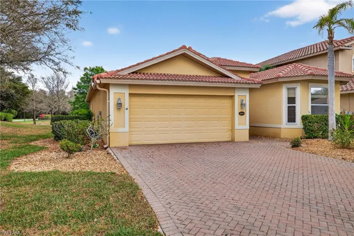 View of front of property with stucco siding, an attached garage, decorative driveway, and a tiled roof