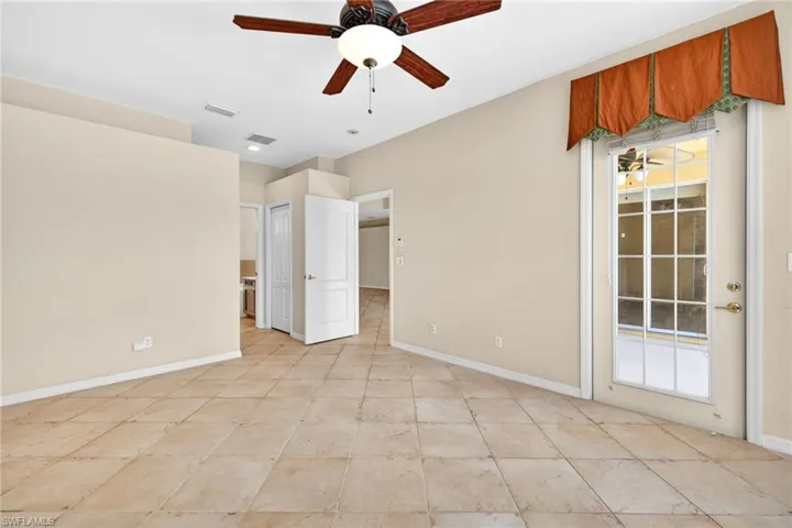Unfurnished bedroom featuring access to outside, ceiling fan, ensuite bath, and a closet