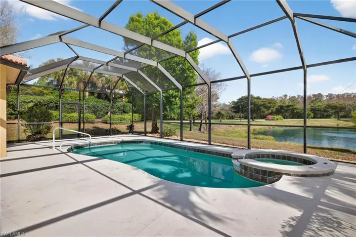 Integrated pool / hot tub with a water view, a sunroom, a lanai, and a patio