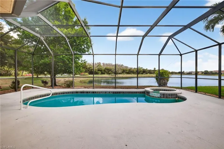 Integrated pool / spa with a sunroom, a lanai, a water view, and a patio area