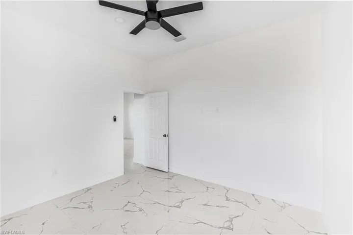 Spare room featuring visible vents, marble finish floor, baseboards, and ceiling fan