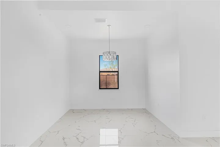 Unfurnished room with visible vents, baseboards, a notable chandelier, and marble finish floor