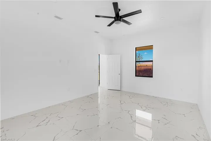 Unfurnished room with visible vents, marble finish floor, baseboards, and a ceiling fan