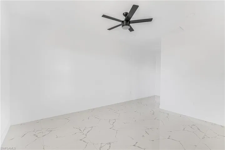 Empty room featuring marble finish floor and ceiling fan