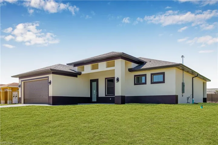 Prairie-style home with stucco siding, driveway, a front lawn, and an attached garage