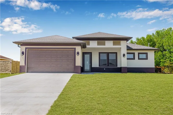 Prairie-style house featuring a front lawn, an attached garage, driveway, and stucco siding