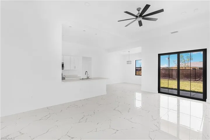 Empty room featuring ceiling fan, visible vents, marble finish floor, and a sink