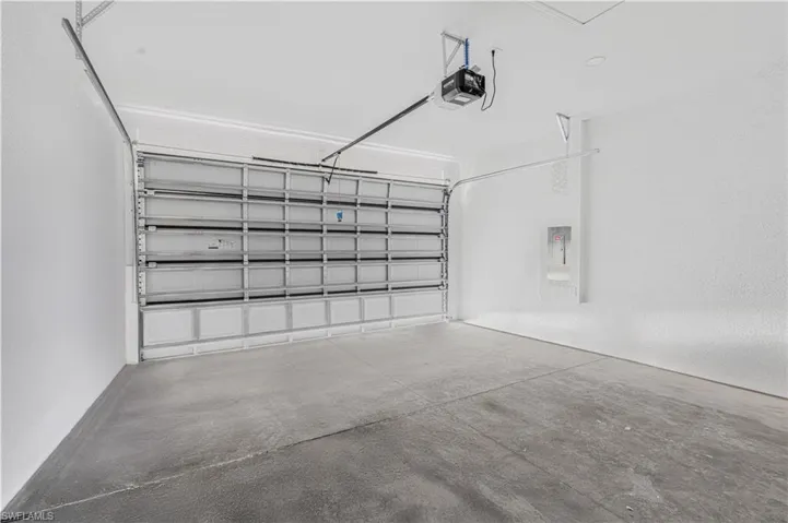 Garage featuring electric panel and a garage door opener