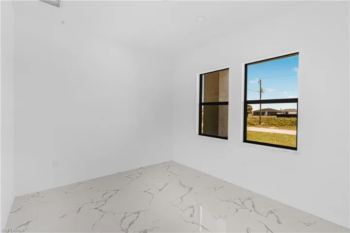 Unfurnished room featuring baseboards and marble finish floor