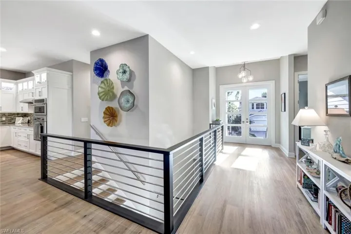 Entryway featuring light LVT floors, french doors, and a notable chandelier