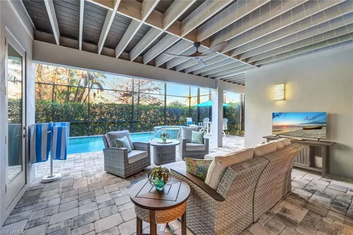 View of patio / terrace with an outdoor living space, glass enclosure, pool water feature, and ceiling fan