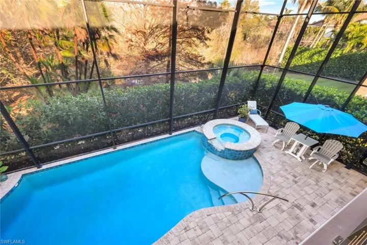View of pool with a lanai, an in ground hot tub, and a patio