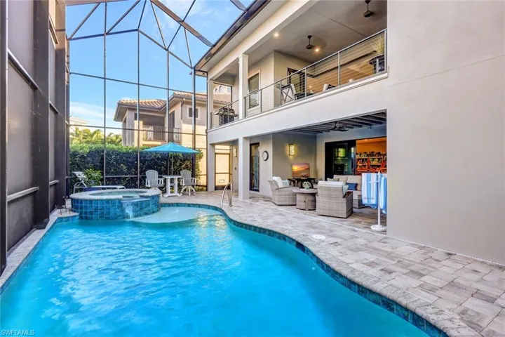 View of swimming pool with an in ground hot tub, a lanai, an outdoor living space, and a patio area